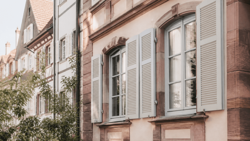 Façade ancienne à Strasbourg avec fenêtres en bois restaurées et volets traditionnels